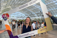 Eine Mitarbeiterin in einem Papprahmen auf der Messe.