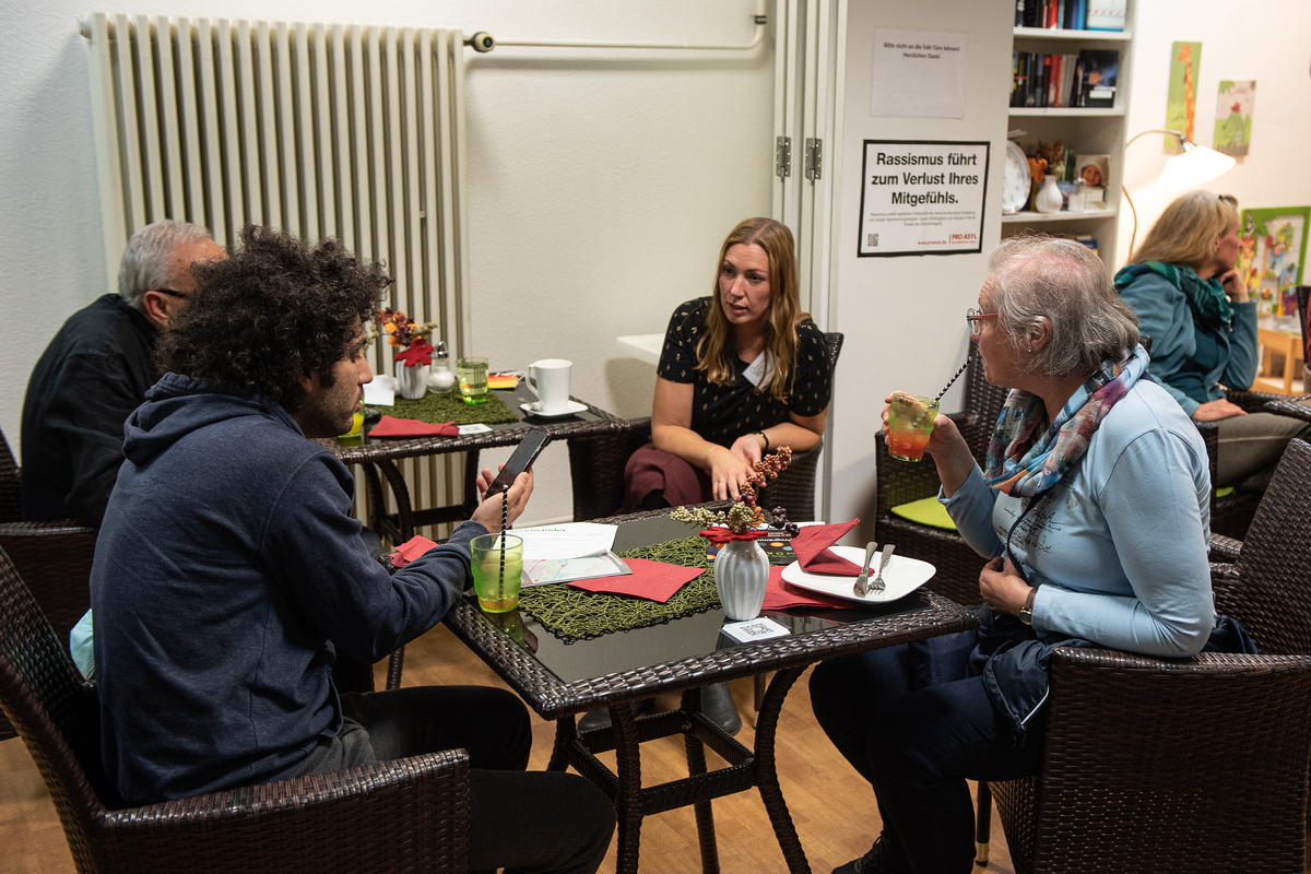 Menschen mit verschiendenen kulturellen Hintergründen sitzen zusammen und reden.