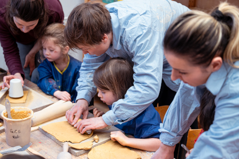 Kinder sitzen an einem Tisch und arbeiten mit Ton