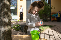 Ein Mädchen entdeckt die kleinen Geschenke im Osternest.