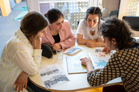 Eine Gruppe Frauen sitzt um einen runden Tisch herum.